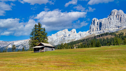 Wooden cabin in front of Rosengarten mountain massif, South Tyrol, Italy