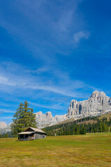 Wooden cabin in front of Rosengarten mountain massif, South Tyrol, Italy