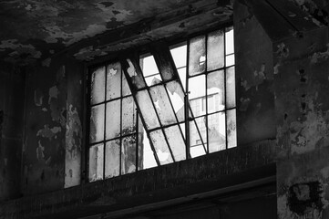 Fototapeta na wymiar Shattered and broken glass windows of an abandoned industrial building. Stara hala - old industrial building in Vysocany, Prague