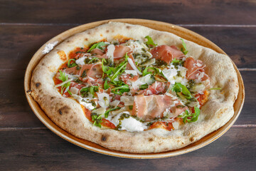 Pizza italienne au jambon cru, mozarella et roquette faite maison dans une assiette en céramique. Gros plan. 