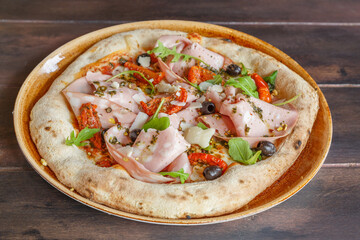 Pizza italienne à la mortadelle faite maison dans une assiette en céramique. Gros plan. 