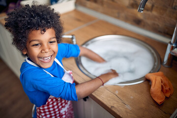 Little Helper's Sudsy Adventure: Afro-American Boy Takes Charge of Dishwashing Duties