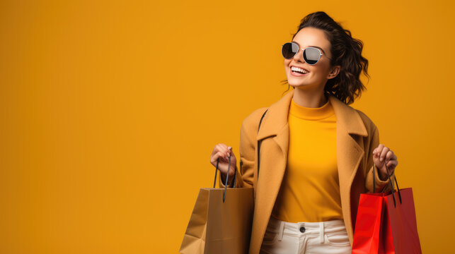 Beautiful attractive smiling woman in sunglasses holding shopping bags posing on yellow background. Created with Generative AI technology.