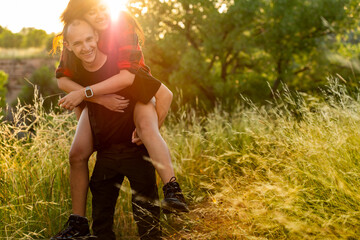 Young couple on hiking trail riding piggyback
