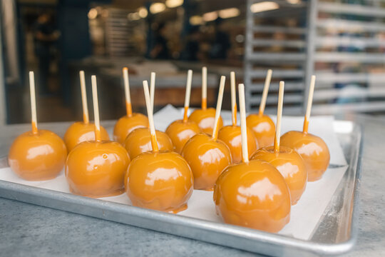 Candied apples on a tray in the window of a bakery.