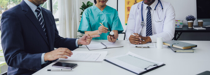 hospital, profession, people and medicine concept - group of happy doctors hands with clipboards and tablet pc computer at meeting in hospital