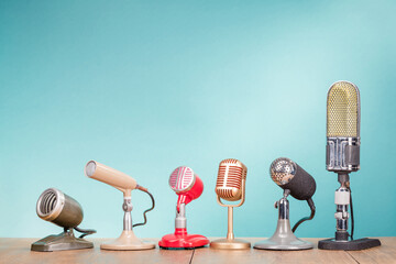 Vintage old microphones for press conference or interview on the oak table front gradient mint blue...