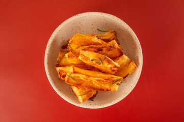Delicious flat lay top view Fried Cassava in Handcrafted White Ceramic Bowl on Red Studio Background