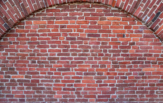 Fototapeta Texture of an old red brick wall with the semicircular arch in brickwork as an old-fashioned architectural background