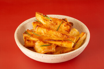 Delicious front view Fried Cassava in Handcrafted White Ceramic Bowl on Red Studio Background
