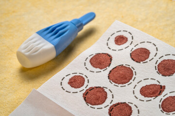 lancet and dry blood spots on a fiber filter for laboratory analysis, home health testing concept - obrazy, fototapety, plakaty
