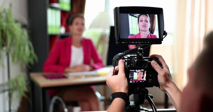 Shooting on a digital camera woman in the office, slowmotion. Blogger, interviews business woman, advertising