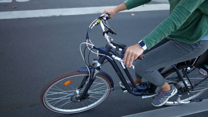 Person holding bicycle riding bike in street commuting