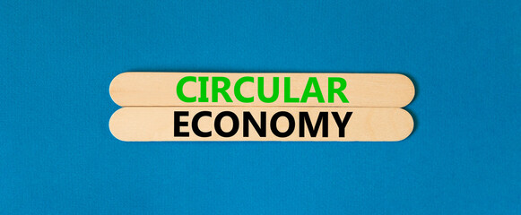 Circular economy symbol. Concept words Circular economy on beautiful wooden stick. Beautiful blue table blue background. Business circular economy concept. Copy space.