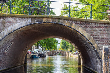 Multiple bridges extend over a canal in Amsterdamn 