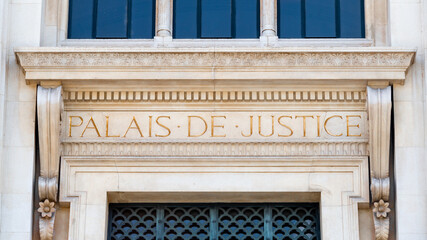Gros plan de l'enseigne écrite au fronton de la façade du palais de justice de Paris, France, avec les mots "Palais de Justice" écrits en Français en lettres dorées