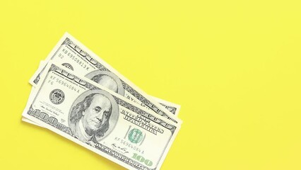 Count bills of one hundred dollars and fifty euros. Putting money on a bright yellow background. The concept of investment, business, money exchange or payout - Powered by Adobe