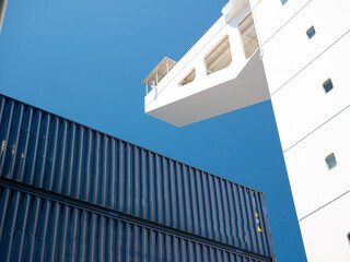 Side wing of navigational bridge and and blue containers stored on deck of ultra large containers ship © Maritime Art Blog
