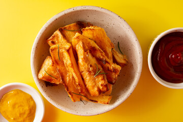 Top view Delicious Fried Cassava in Handcrafted White Ceramic Bowl on Yellow Studio Background