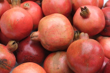 Red pomegranates on a market counter for sale ,close up view