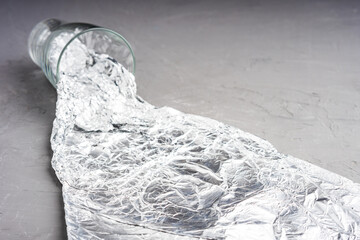 shallow depth of field on a glass beaker from which the foil flows out like water