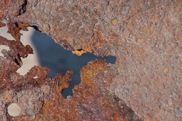 metal texture from a piece of old iron in brown rust with a hole