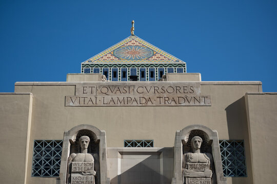 The exterior of the historic, iconic Los Angeles Public Library building in downtown Los Angeles. Sculptures adorn the facade, with a pyramid atop the building.