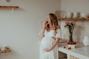 Pregnant woman in the kitchen with fruits