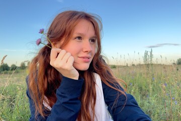 happy girl in the field in summer at sunrise or sunset, enjoying nature