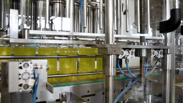Automated chemical products filling. Plastic PET bottles filled with liquid washing detergent move along the conveyor belt. Automatic bottle filling machine.