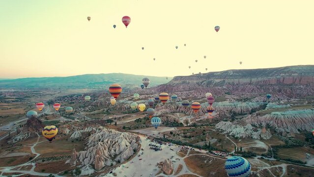 Drone point of view footage of hot air balloons above spectacular volcanic landscape of Cappadocia. Goreme national park. UNESCO World Heritage site. Nevsehir province, Turkiye