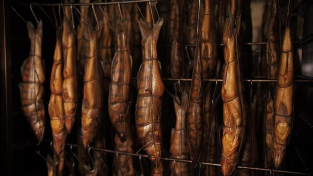 Smoked fish hanging in a smoking cabinet at a fish factory