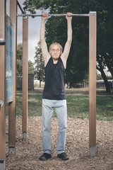 Obraz premium Ugly man of bad condition trying workout in outdoor gym