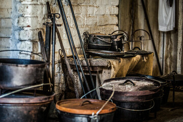Old antique pots and kettles in cabin.