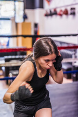 Fototapeta na wymiar K1 mixed martial arts, Hispanic young woman fighter doing aerobox for cardio. Power strengh action