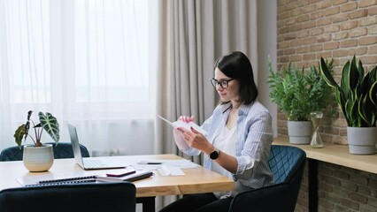 Young business woman reading an important letter, rejoicing at good news