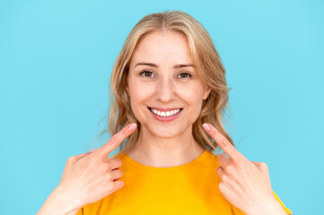 Obraz premium Happy woman point fingers on healthy white teeth