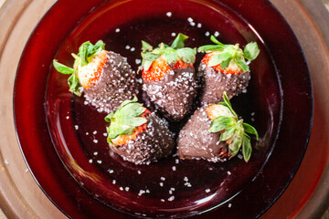 Chocolate dipped strawberries sprinkled with sugar crystals.