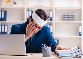 Head injured male employee working in the office