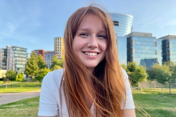 portrait of a young girl on the background of the business center in summer weather