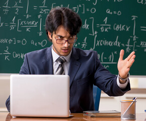 Young male math teacher in classroom