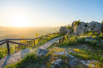 Walking path with wooden fence on the ruins of Zahara Castle at sunset - Zahara de la Sierra,...