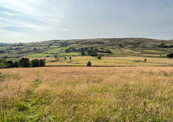 Fototapeta premium Rural landscape, with extensive fields, and distant hills near, Delph, UK