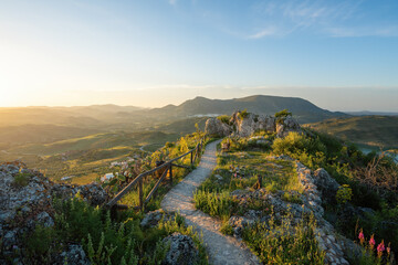 Walking path with wooden fence on the ruins of Zahara Castle at sunset - Zahara de la Sierra, Andalusia, Spain