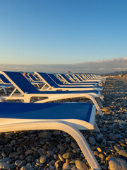   Beach chairs. Lots of empty sunbeds on the pebbles. The concept of commerce on the beach. Sunbed...