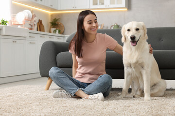 Happy woman with cute Labrador Retriever dog on floor at home. Adorable pet