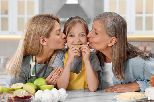 Three generations. Grandmother, her daughter and granddaughter in kitchen