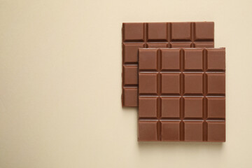Delicious chocolate bars on beige background, flat lay. Space for text