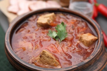 Tasty borscht in bowl on table, closeup