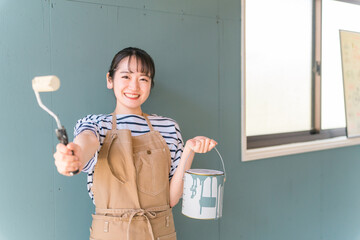 壁の塗装をする日本人女性（セルフリノベーション）
